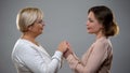 Mature mother and adult daughter holding hands looking each other, closeness Royalty Free Stock Photo