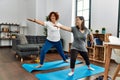 Mature mother and down syndrome daughter doing exercise at home