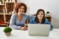 Mature mother and down syndrome daughter using computer laptop at home Royalty Free Stock Photo