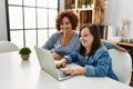 Mature mother and down syndrome daughter using computer laptop at home Royalty Free Stock Photo