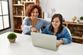 Mature mother and down syndrome daughter using computer laptop at home Royalty Free Stock Photo