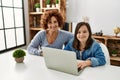 Mature mother and down syndrome daughter using computer laptop at home Royalty Free Stock Photo