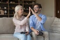Mature mother and young adult son having fun play videogames