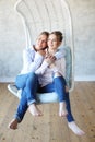 Mature motherand daughter hugging each other in armchair. Royalty Free Stock Photo