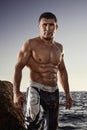 Mature muscular athlete standing in a beach during sunset Royalty Free Stock Photo