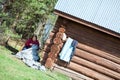 Mature needlewoman sitting in shade and working near house