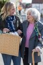 Mature Neighbor Helping Senior Woman To Carry Shopping