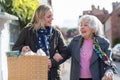 Mature Neighbor Helping Senior Woman To Carry Shopping