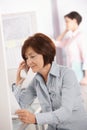 Mature office worker woman using landline phone