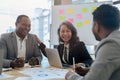 Mature older businesswoman negotiating growth business plan with diverse executive managers at boardroom