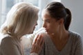 Mature older woman hugging shoulders of desperate unhappy adult daughter.