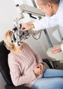 Mature optician examinating eyesight with aid of slit lamp Royalty Free Stock Photo