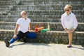 Mature people in sportswear, man and woman training outdoors, dog stretching on stairs. Warming up Royalty Free Stock Photo