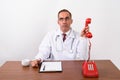 Mature Persian man doctor working behind desk Royalty Free Stock Photo