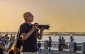 Mature photographer looking out people to shoot on Dnepr river embankment