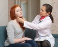 Mature physician palpates neck of teenager patient Royalty Free Stock Photo
