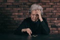Mature poor woman counting coins at table Royalty Free Stock Photo