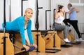 Sporty mature female doing stretching exercises on pilates reformer Royalty Free Stock Photo
