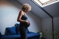 Mature pregnant woman standing at home