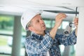 Mature professional handyman replacing light bulb