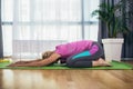 Woman exercising and stretching her body doing flexibility exercises, sitting on a yoga mat indoor Royalty Free Stock Photo