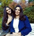 Mature real mother with daughter outside autumn fall in park, recreation concept