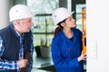 Mature repairman helping woman to use builder level Royalty Free Stock Photo