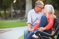 Mature Romantic Couple Sitting On Park Bench Together Royalty Free Stock Photo