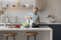 Mature 60s homeowner man cooking dinner in kitchen