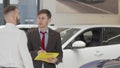 Mature salesman helping male customer choosing automobile to buy Royalty Free Stock Photo