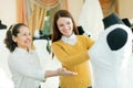 Saleswoman helps bride chooses bridal gown Royalty Free Stock Photo