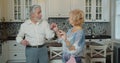 Mature senior couple dancing in the kitchen, beautiful romantic older grandparents relaxing having fun together at home Royalty Free Stock Photo