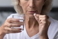 Mature senior lady taking pills for relieving mental disease Royalty Free Stock Photo