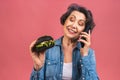 Mature senior woman eating burger with satisfaction. Grandmother enjoys tasty hamburger takeaway, delicious bite of burger, using