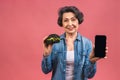 Mature senior woman eating burger with satisfaction. Grandmother enjoys tasty hamburger takeaway, delicious bite of burger,