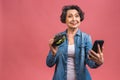 Mature senior woman eating burger with satisfaction. Grandmother enjoys tasty hamburger takeaway, delicious bite of burger, using