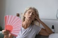 Mature senior woman exhausted with heat, swelter, summer weather