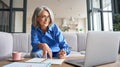 Mature senior woman having video call virtual class at home.