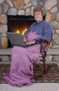 Mature Senior Woman Laptop Computer by Fireplace