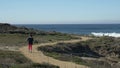 Mature senior women running smiling. Pacific ocean in background