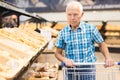 mature senor choosing bread and baking in grocery section of supermarket Royalty Free Stock Photo