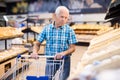 Mature senor choosing bread and baking in grocery section of supermarket Royalty Free Stock Photo