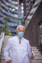 Mature serious doctor on street with protective mask I am late Royalty Free Stock Photo