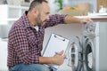 mature serviceman looking at washing machine Royalty Free Stock Photo