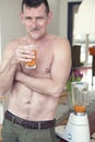 Mature shirtless man drinking glass of juice Royalty Free Stock Photo