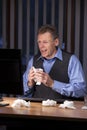 Mature sick businessman working at a desk at home