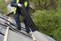 Workman install tile on roof of new house under construction