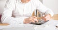 Mature small business owner calculating finance bills of activity - Entrepreneur using laptop and calculator to work and to Royalty Free Stock Photo