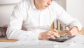 Mature small business owner calculating finance bills of activity - Entrepreneur using laptop and calculator to work and to Royalty Free Stock Photo