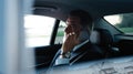 Mature smiling man talking over phone while sitting in taxi. Businessman talking over cellphone while commuting. Royalty Free Stock Photo